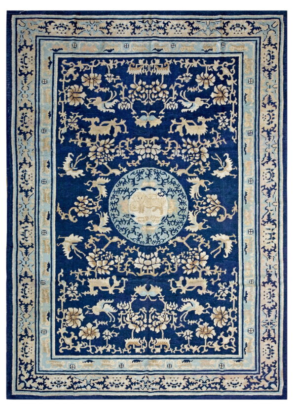 Dark blue rug with detailed beige and pale blue traditional patterns, including a central medallion.