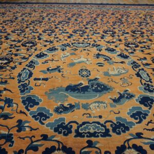Orange field rug with extensive dark blue floral patterns and a light blue animal medallion.