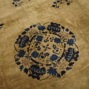 Gold high-pile rug featuring a round medallion design with intricate blue and tan floral motifs.