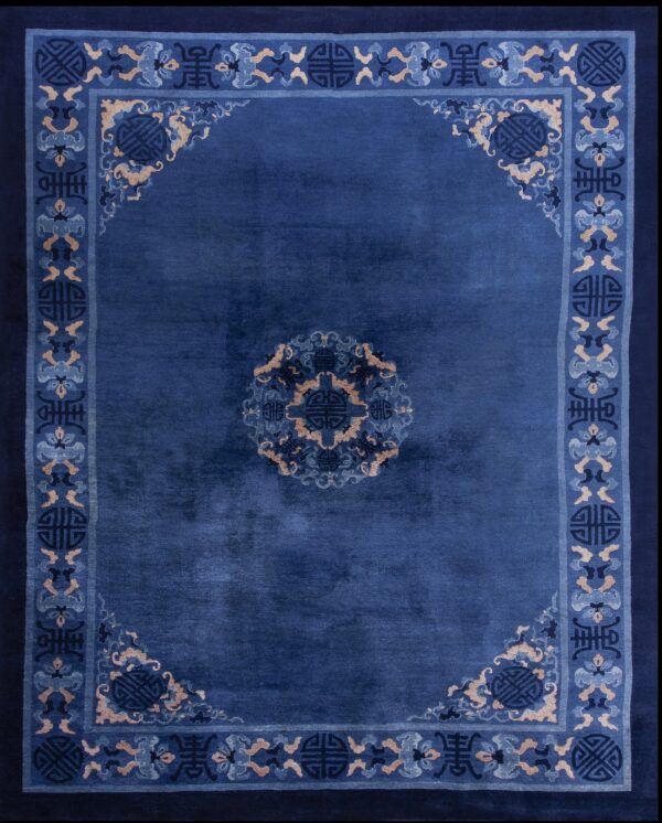 Deep blue rug with an ornate medallion and geometric border pattern in light blue and tan accents.