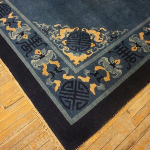 Blue rug corner with indigo, gold, and pale blue pattern rests on warm-toned wooden floors.