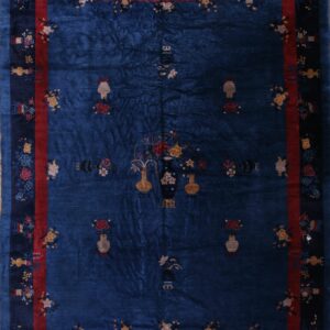 Deep blue rug patterned with scattered vases and flowers, framed by contrasting red and dark blue borders.