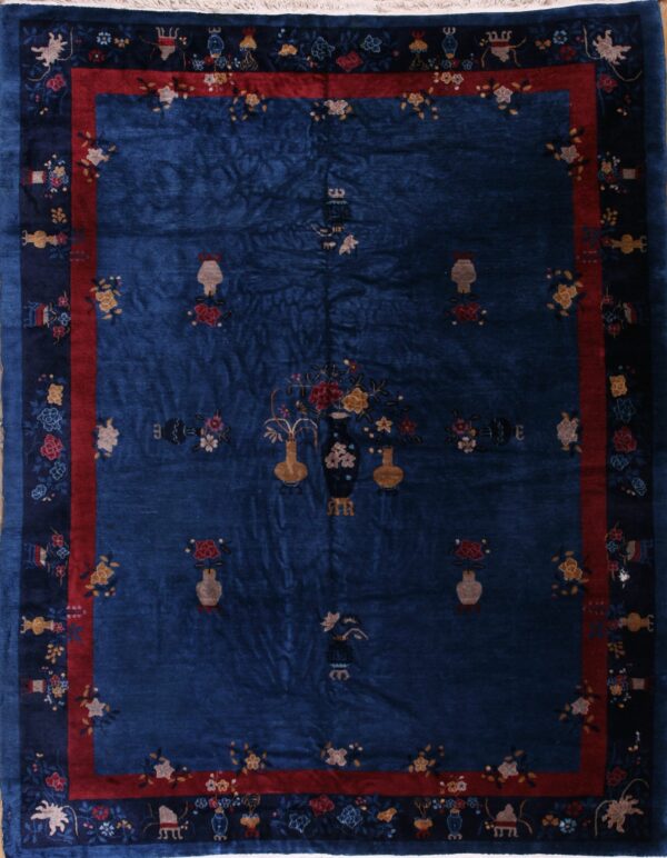 Deep blue rug patterned with scattered vases and flowers, framed by contrasting red and dark blue borders.