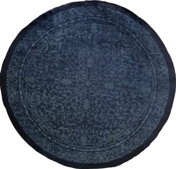 Circular navy blue rug with intricate light blue traditional motifs and a subtle darker border.