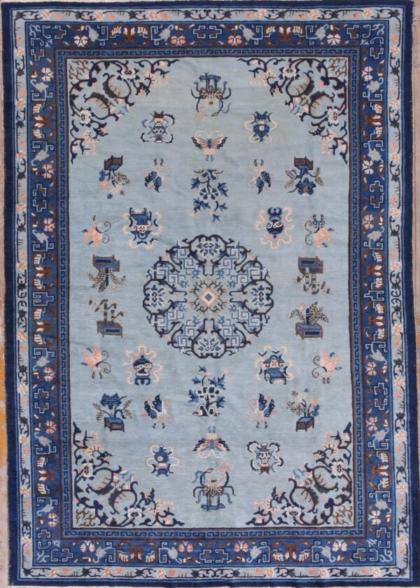 Light blue rug with a dark blue multi-layered border and scattered floral and emblematic motifs.
