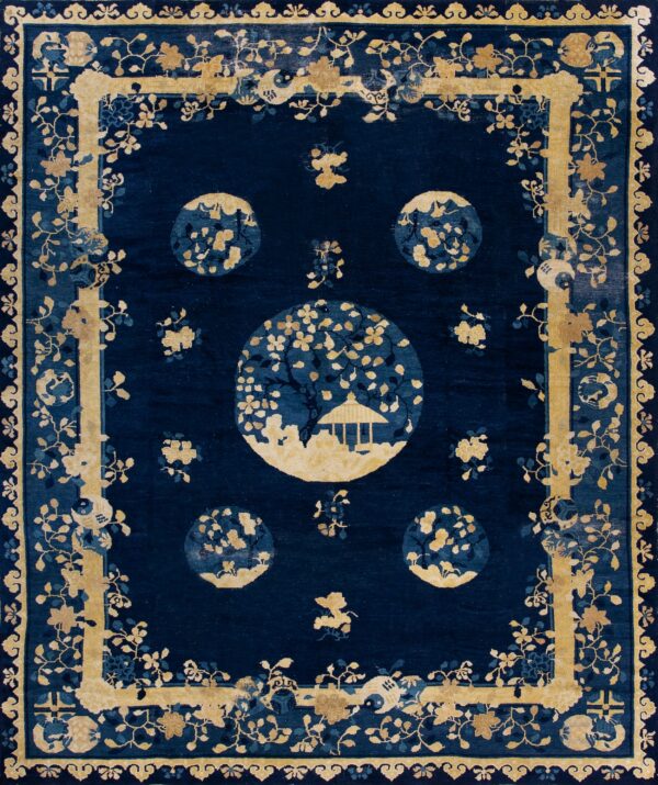 Deep indigo rug with contrasting gold floral patterns and medallions featuring a small pavilion design.