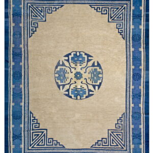 Beige rug with a bold blue border featuring geometric fretwork and a stylized central medallion.