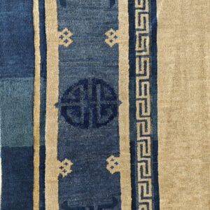 Blue and tan rug borders feature vertical stripes, geometric medallions, and a repeating meander or fretwork pattern.