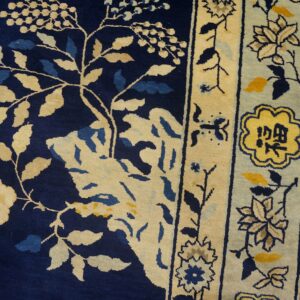 Floral navy rug with cream, blue, and yellow patterns borders a light wooden floor.