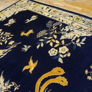 Dark blue rug featuring gold and cream birds, vines, and a goat, bordered by decorative yellow cartouche motifs.