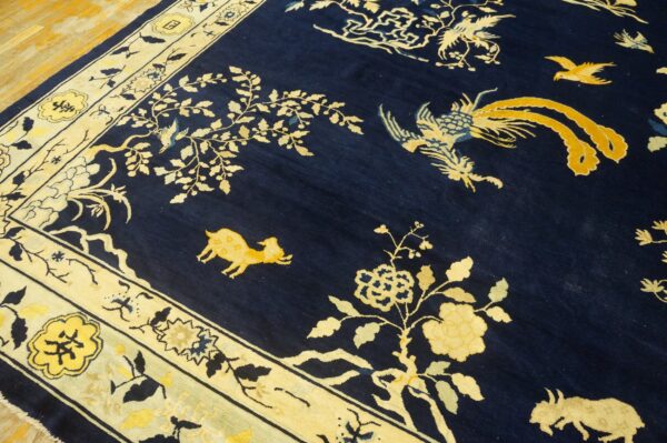 Navy blue rug with yellow mythical creatures and branches, featuring a thick cream border on hardwood flooring.