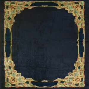 Dark blue rug featuring an ornate, multicolored geometric border defining the central low-pile field.