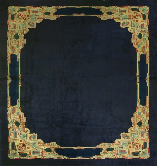 Dark blue rug featuring an ornate, multicolored geometric border defining the central low-pile field.