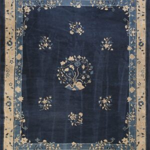Dark blue rug with tan and light blue floral designs, centered medallion, and decorative wide borders.
