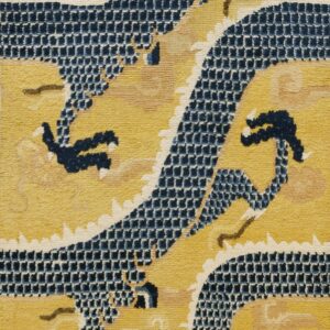 A vertical view of a gold and navy blue rug featuring a central stylized dragon pattern.