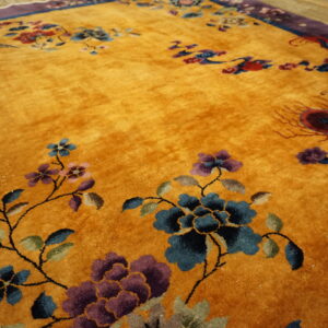Deep gold high-pile rug featuring blue, purple, and red floral designs and stylized animal figures.