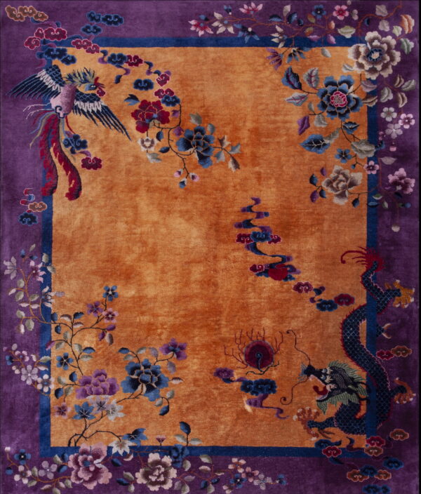 Orange field rug with a deep purple border featuring detailed blue dragon and phoenix motifs.