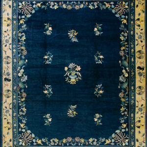 Deep blue rug featuring scattered pale floral motifs and a wide beige border with detailed medallions.