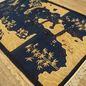 High contrast navy blue and gold rug featuring stylized dragons, birds, bamboo, and cloud motifs on wood flooring.