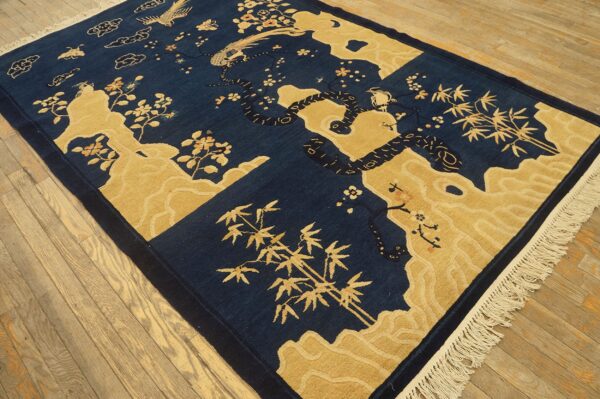 High contrast navy blue and gold rug featuring stylized dragons, birds, bamboo, and cloud motifs on wood flooring.