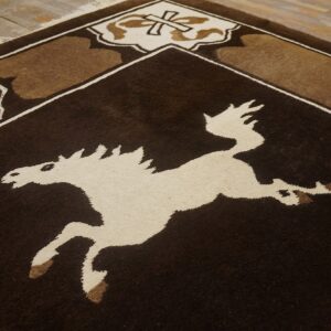 Dark brown and cream rug featuring a large stylized horse and geometric borders on rustic wooden flooring.