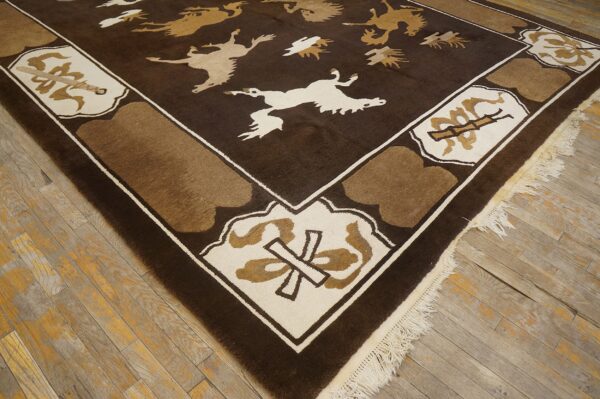 Dark brown rug with stylized tan and cream animals and geometric border on worn wooden flooring.