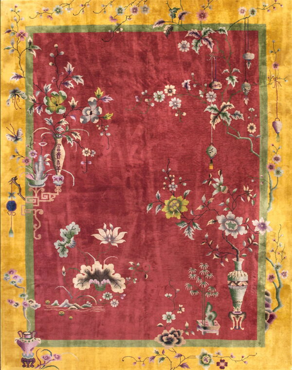 High-pile red rug with elaborate floral patterns, framed by a green line and a broad golden yellow border.