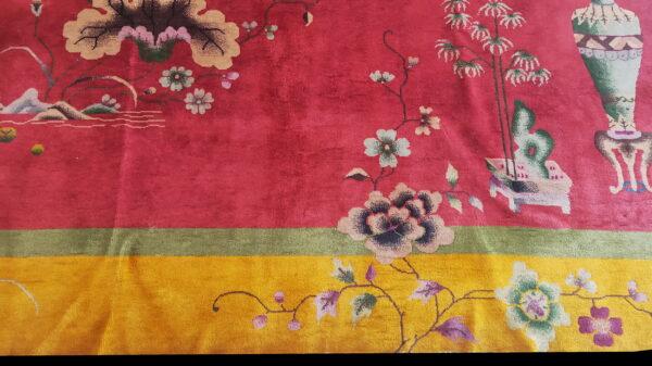 Ornate pink rug with a bright yellow lower section featuring detailed flowers, vines, and vase patterns.