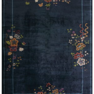 Navy blue rug with a light blue line border and multicolored, intricate floral patterns on the perimeter.