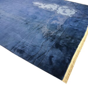 A plush blue rug features lighter blue carved details of dragons, clouds, and waves, with yellow fringe visible.