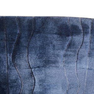 Detail of a dark blue plush rug featuring vertical textured lines creating a wavy pattern.