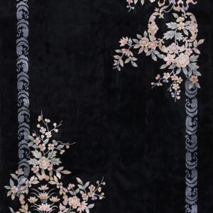 Black rug with a gray scroll border and delicate pastel floral clusters in two opposite corners.