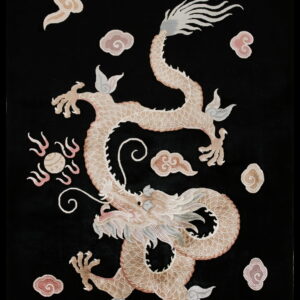 Intricate black rug displaying a tan and pink coiled dragon pattern with scattered pale clouds.