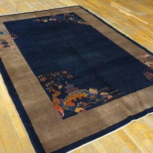 Navy blue rug with a wide brown border featuring detailed multicolored patterns rests on hardwood floors.