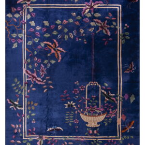 Deep blue rug with a plush pile texture and an inner border framing pink floral and butterfly designs.