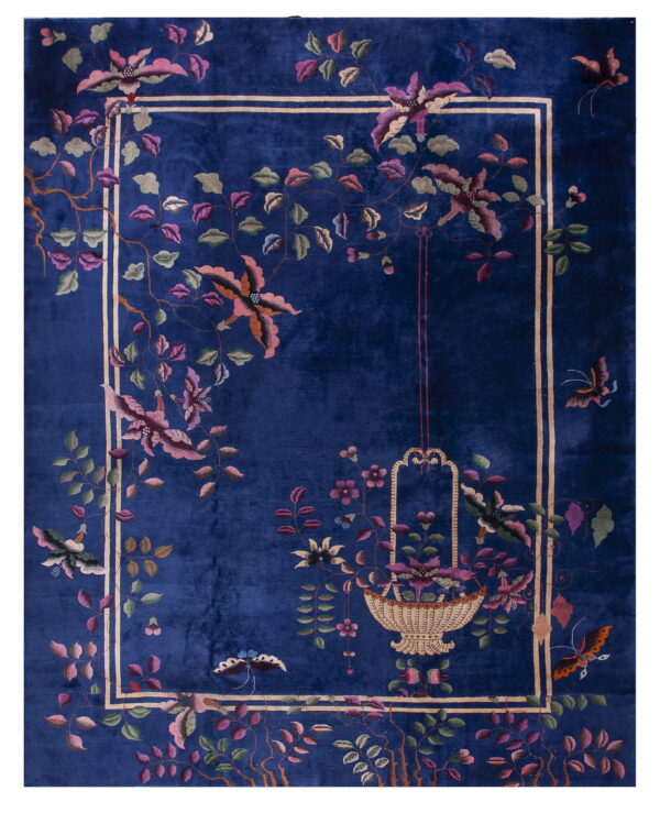 Deep blue rug with a plush pile texture and an inner border framing pink floral and butterfly designs.