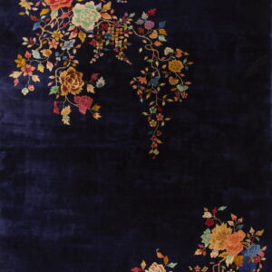 Navy blue rug with high pile texture and colorful floral clusters in opposite corners.