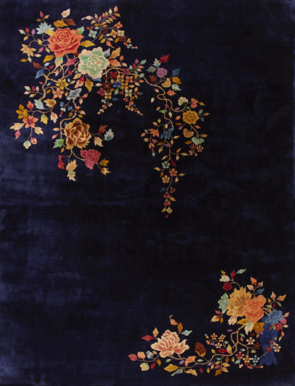 Navy blue rug with high pile texture and colorful floral clusters in opposite corners.