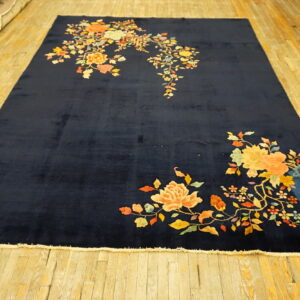 Plush navy rug featuring bright yellow and orange floral patterns, laid on yellow hardwood.