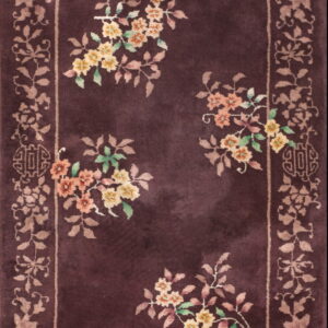 Dark plum high-pile rug featuring a scattered yellow and peach floral pattern and decorative beige border.