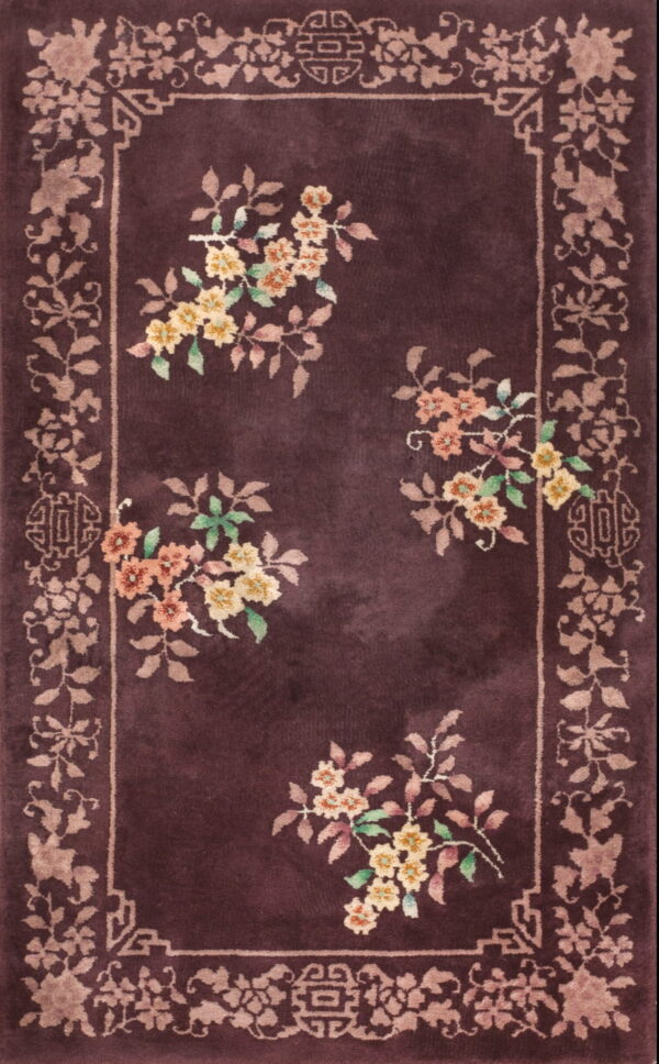 Dark plum high-pile rug featuring a scattered yellow and peach floral pattern and decorative beige border.