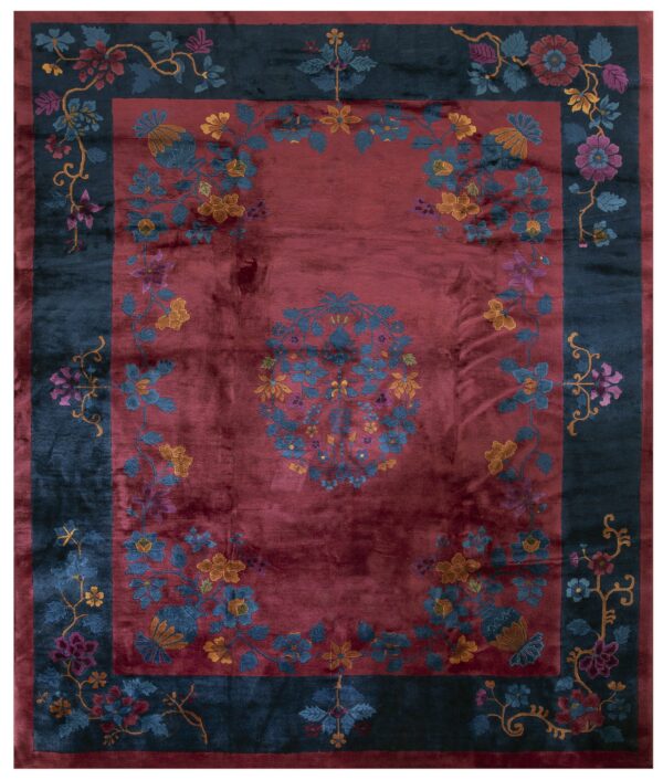 Red central field rug with a teal border and multicolored floral vine pattern.