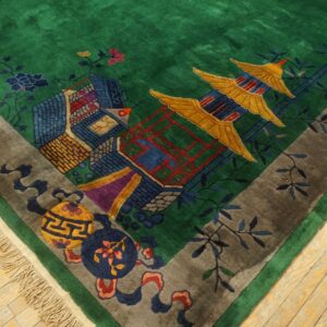 High-pile green rug with a multicolored pagoda and landscape pattern bordered in gray on light wood flooring.