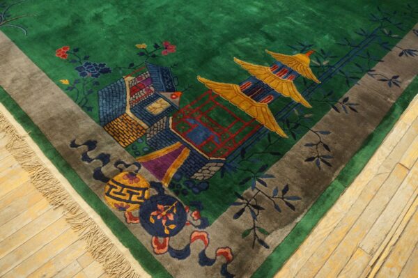 High-pile green rug with a multicolored pagoda and landscape pattern bordered in gray on light wood flooring.