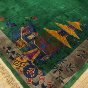 Plush green rug with a multicolored scenic pattern of pagodas, floral elements, and a contrasting gray border.