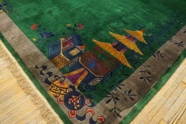 Plush green rug with a multicolored scenic pattern of pagodas, floral elements, and a contrasting gray border.