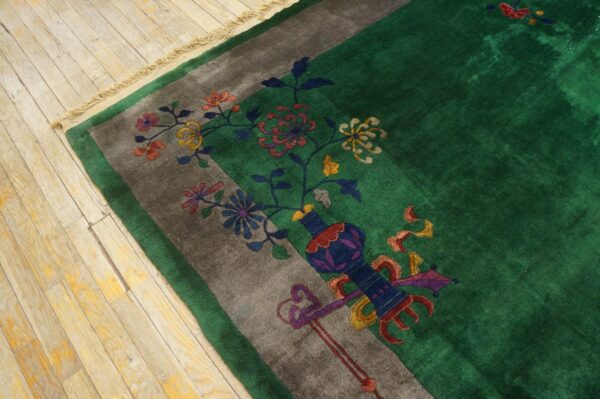 Emerald green high-pile rug border featuring multicolored flowers and a vase on light wood floor.