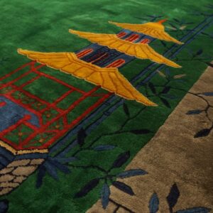 High-pile green rug featuring a pagoda motif in yellow, blue, and red with a textured brown foliage border.
