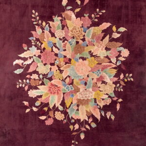 Velvety maroon rug with a central cluster of multicolored flowers in soft pink, peach, and green.