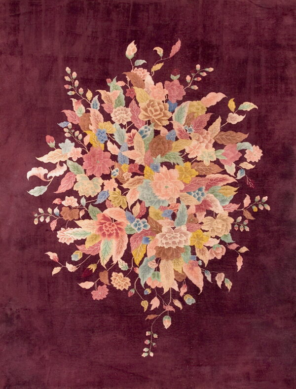 Velvety maroon rug with a central cluster of multicolored flowers in soft pink, peach, and green.
